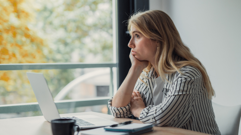 Christian woman pausing at her desk, working through business overwhelm with clarity and calm