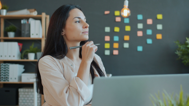A Christian woman pausing at her desk, discerning what's hers to carry through mental exhaustion