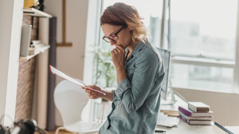 A Christian woman pausing at her desk, discerning whether to close her business